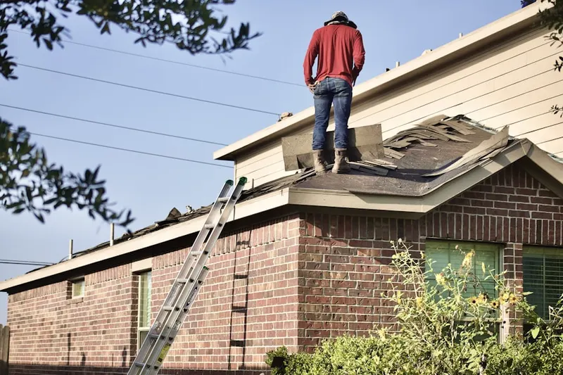 Professional roofer working on a residential roof in Hooes